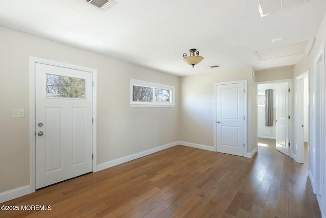 foyer entrance featuring visible vents, baseboards, and hardwood / wood-style floors