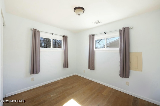 unfurnished room with baseboards and wood finished floors