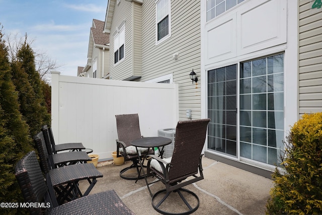 view of patio with central AC unit and fence