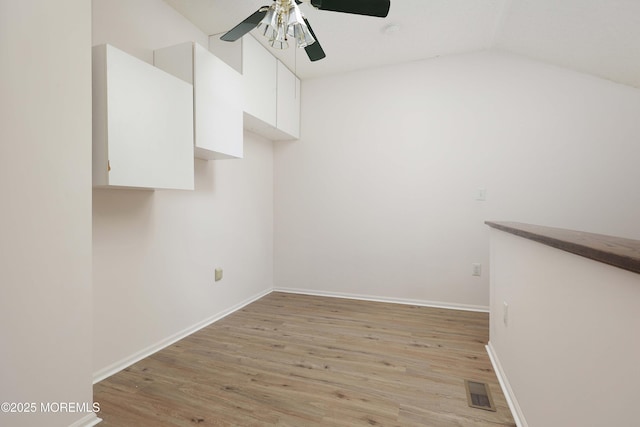 spare room featuring baseboards, a ceiling fan, visible vents, and light wood-type flooring