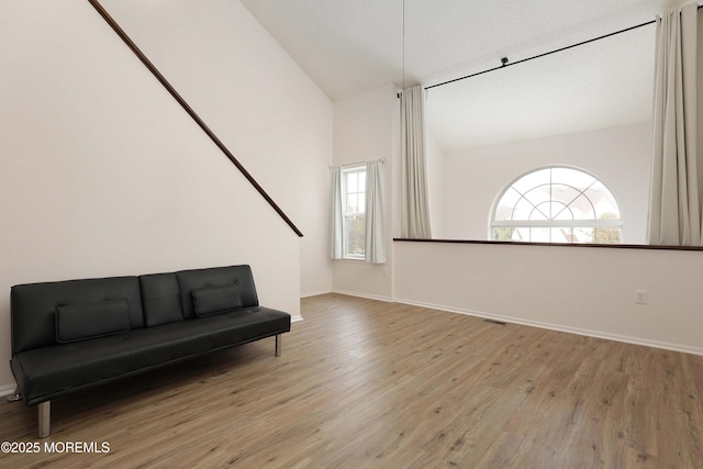 sitting room with vaulted ceiling, baseboards, and wood finished floors