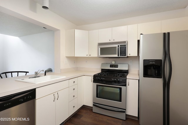 kitchen featuring dark wood-style floors, a sink, light countertops, white cabinets, and appliances with stainless steel finishes