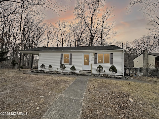 view of front of home featuring a carport and fence