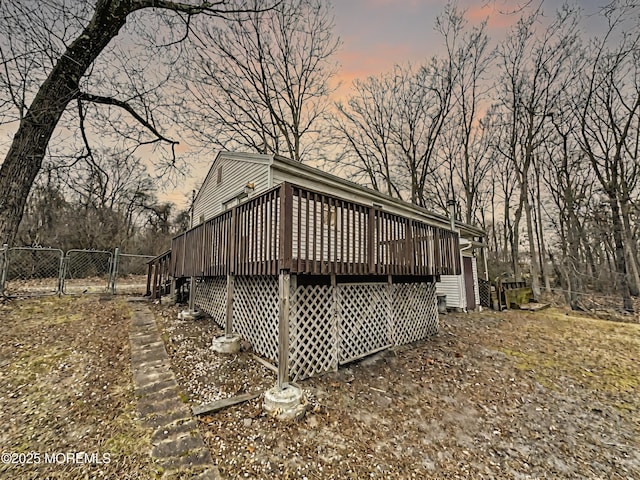 rear view of house featuring fence, a deck, and a gate