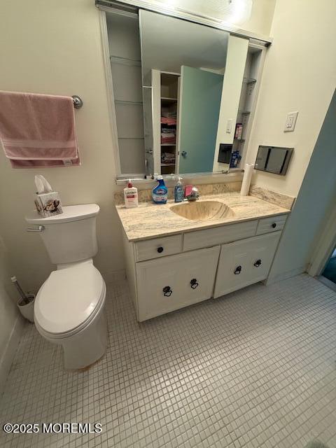 bathroom featuring tile patterned flooring, toilet, and vanity