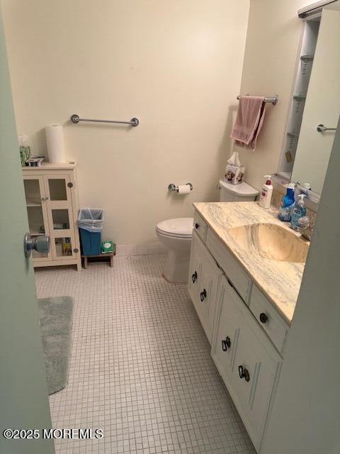 bathroom featuring tile patterned flooring, toilet, and vanity