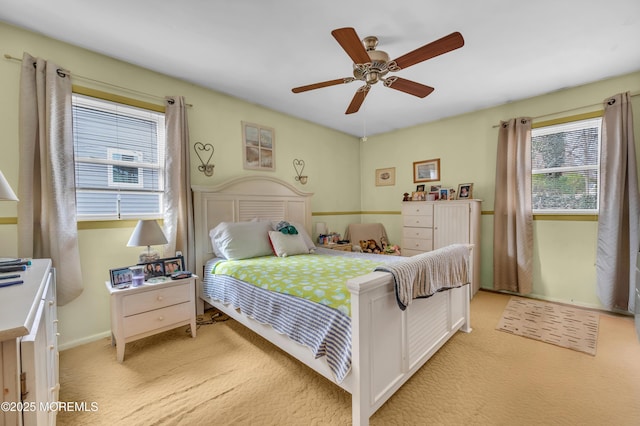 bedroom featuring baseboards, light carpet, and ceiling fan