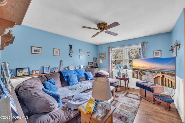 living area with wood finished floors and ceiling fan