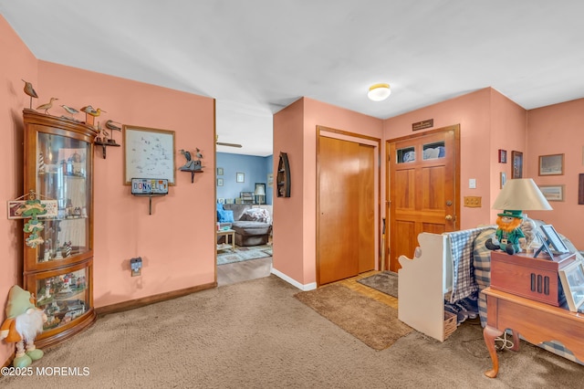 foyer with baseboards and carpet floors