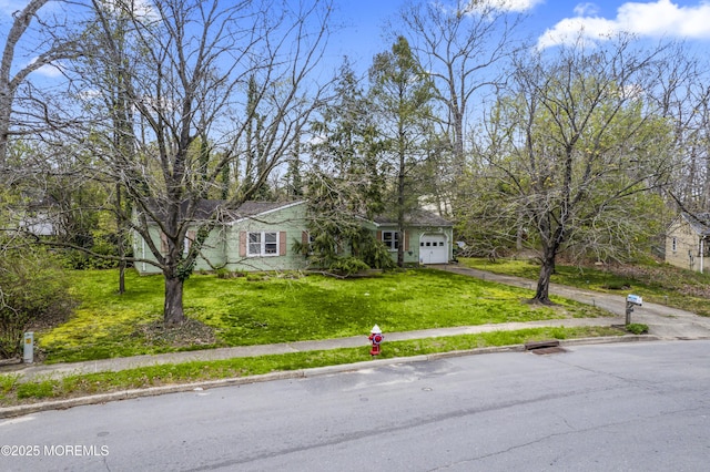 view of front of property with aphalt driveway, a front lawn, and an attached garage