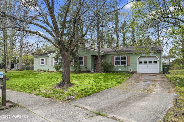 ranch-style house with aphalt driveway, a front yard, a garage, and a shingled roof