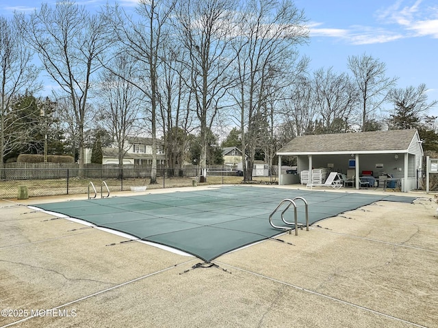 pool with a patio area and fence