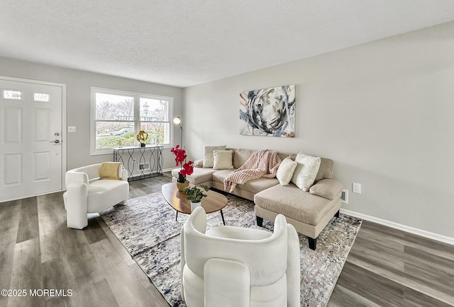 living area with a textured ceiling, baseboards, and wood finished floors