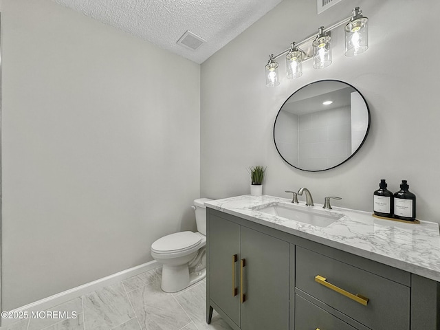 bathroom featuring vanity, baseboards, visible vents, a textured ceiling, and toilet