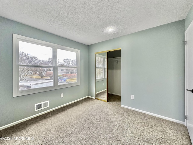 unfurnished bedroom with baseboards, visible vents, and carpet floors