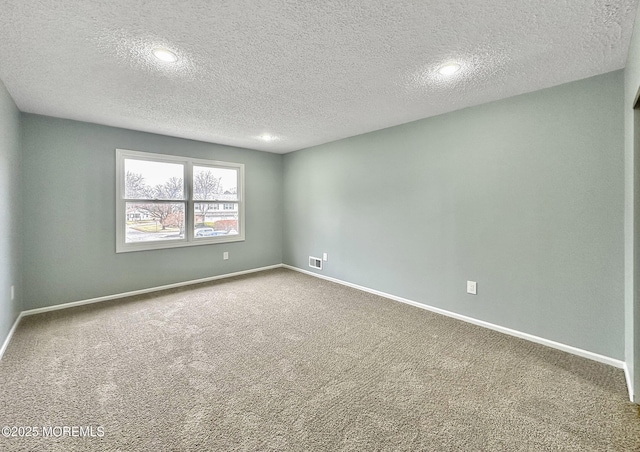 unfurnished room with baseboards, carpet floors, a textured ceiling, and visible vents