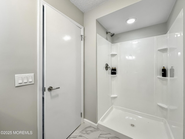 full bathroom with marble finish floor, a textured ceiling, and walk in shower