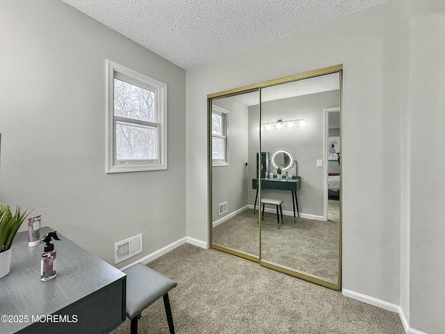 carpeted home office with visible vents, a textured ceiling, and baseboards