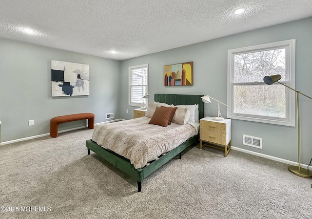 bedroom featuring visible vents, baseboards, a textured ceiling, and carpet flooring