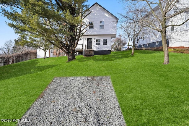 back of house with fence and a lawn