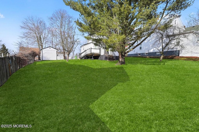 view of yard featuring a storage shed, an outdoor structure, and fence