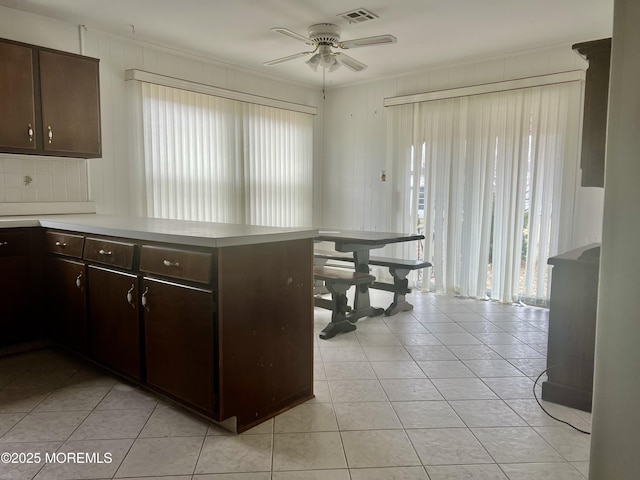 kitchen featuring dark brown cabinetry, a ceiling fan, visible vents, and a peninsula