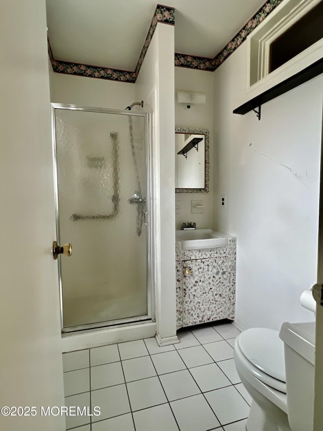 bathroom featuring tile patterned flooring, a stall shower, toilet, and vanity