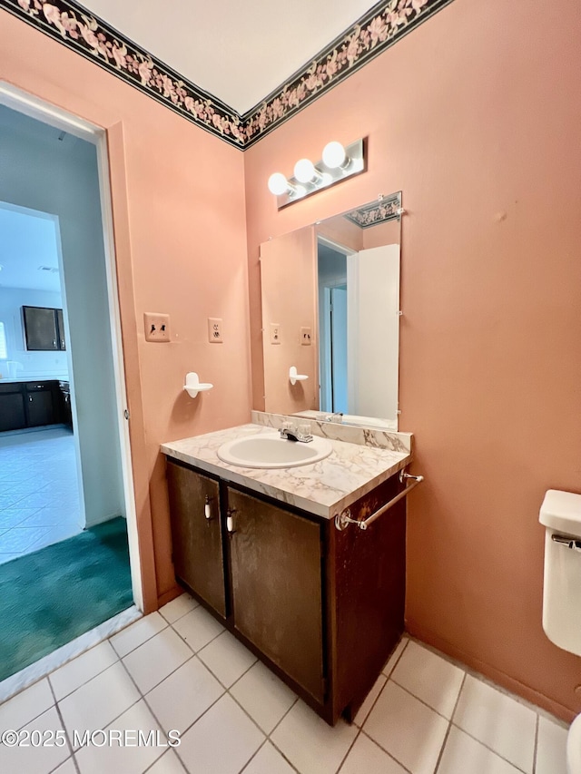 half bathroom with tile patterned flooring, toilet, and vanity