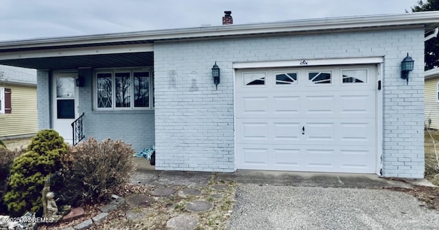 exterior space featuring a garage, brick siding, and a chimney