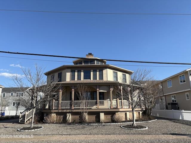 american foursquare style home with a porch, a chimney, and fence