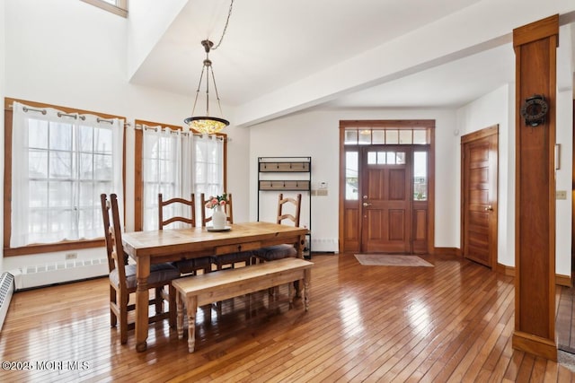 dining space featuring baseboards, light wood-type flooring, and a chandelier