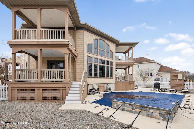 back of house with a fenced in pool, a patio, a balcony, and fence