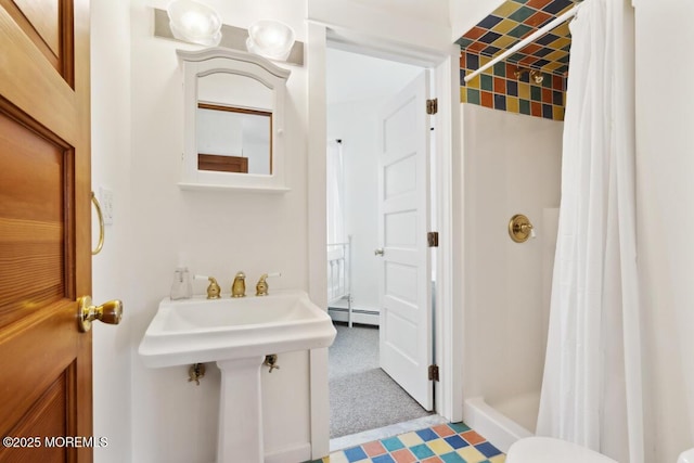 bathroom featuring a shower stall and a baseboard radiator