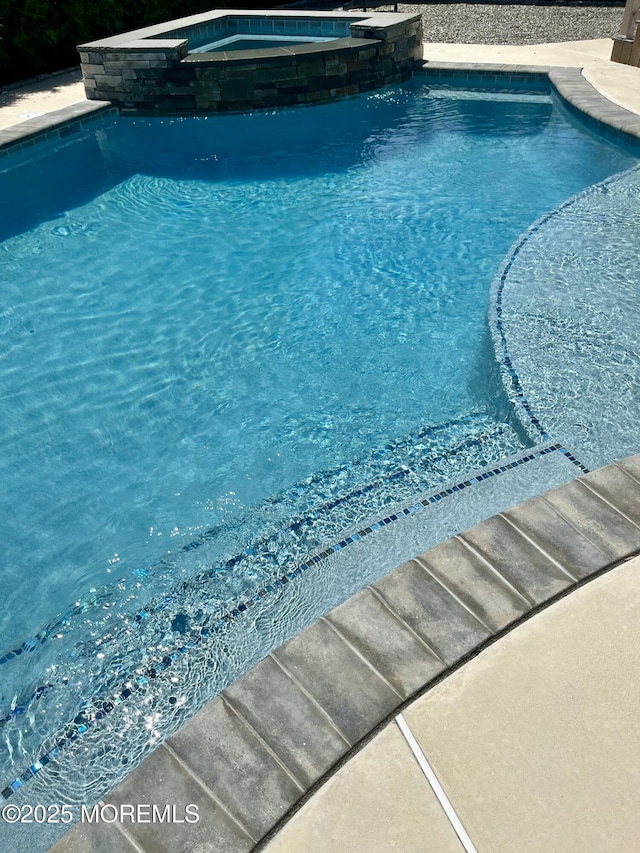 view of swimming pool featuring a pool with connected hot tub