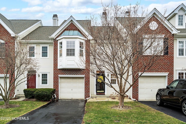 multi unit property featuring a garage, driveway, a chimney, and a shingled roof