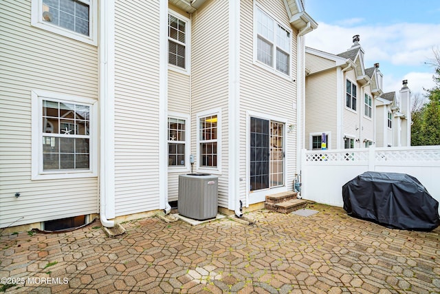 view of patio / terrace featuring area for grilling, cooling unit, entry steps, and fence