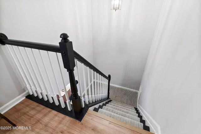 staircase featuring baseboards and wood finished floors