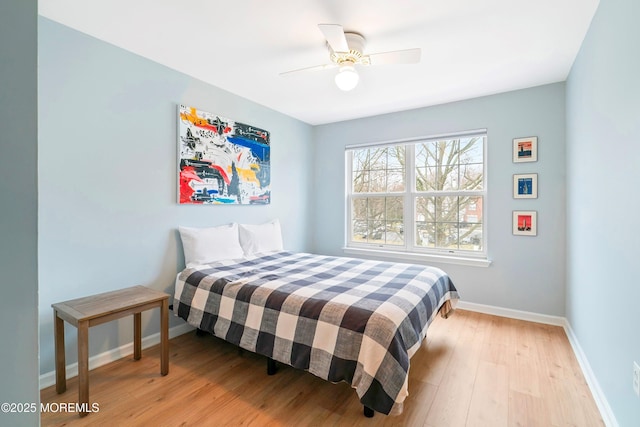 bedroom with ceiling fan, baseboards, and wood finished floors