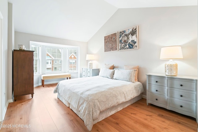 bedroom featuring lofted ceiling, light wood-style floors, and baseboards