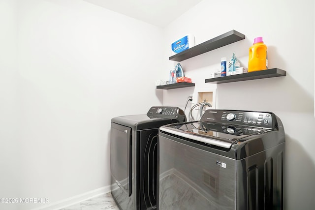 laundry room featuring laundry area, washing machine and dryer, marble finish floor, and baseboards