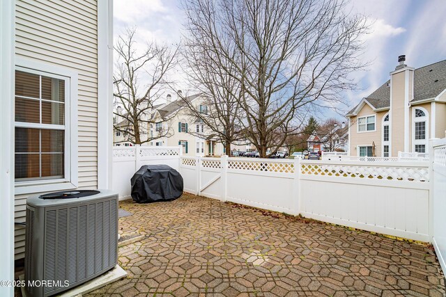 view of patio / terrace with grilling area, cooling unit, a residential view, and a fenced backyard