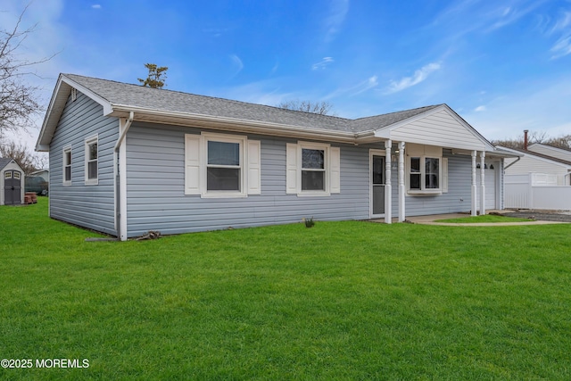 ranch-style home with a front yard, an attached garage, and a shingled roof