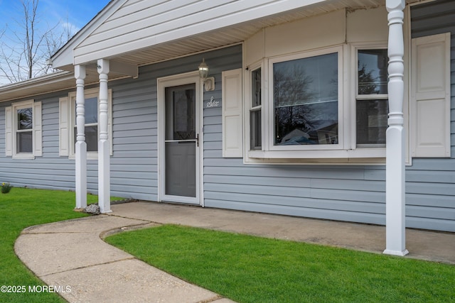 entrance to property featuring a lawn