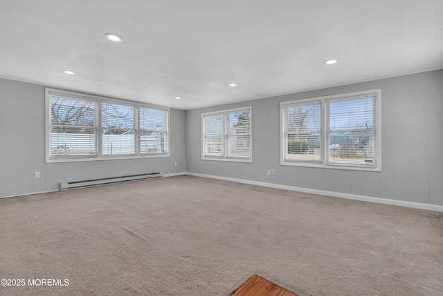 carpeted spare room with a baseboard heating unit, recessed lighting, and baseboards