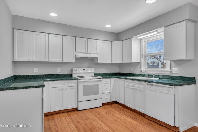 kitchen featuring white appliances, a sink, light wood-style floors, under cabinet range hood, and white cabinetry