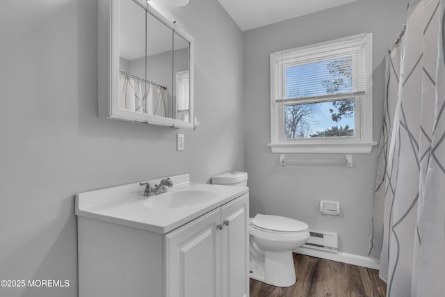 full bath with vanity, wood finished floors, baseboards, a baseboard heating unit, and toilet