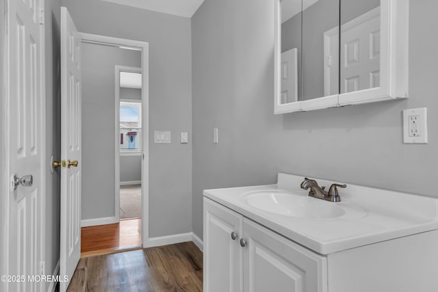 bathroom featuring vanity, wood finished floors, and baseboards