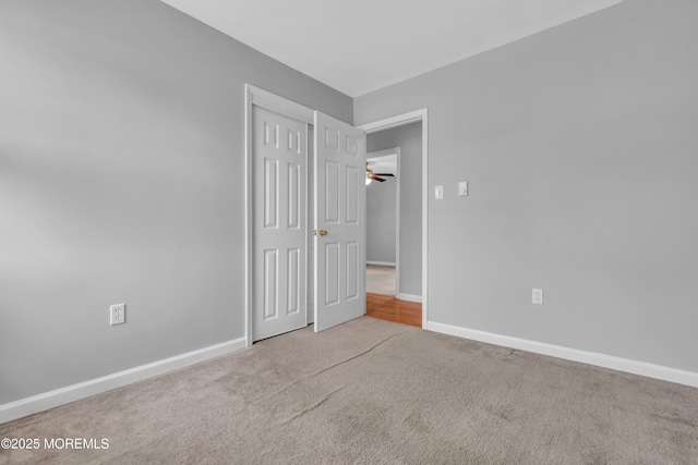 spare room with baseboards, carpet, and a ceiling fan