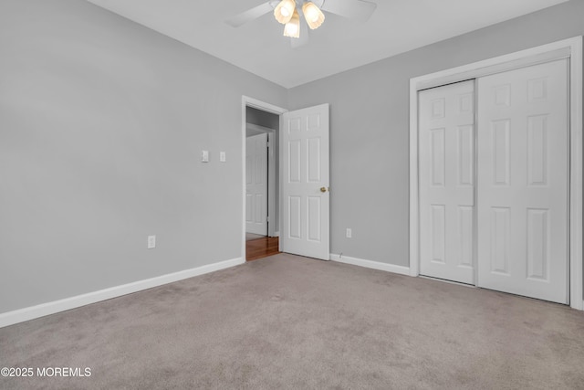 unfurnished bedroom with a ceiling fan, carpet, baseboards, and a closet