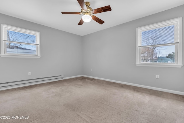 carpeted spare room featuring baseboard heating, baseboards, and a ceiling fan